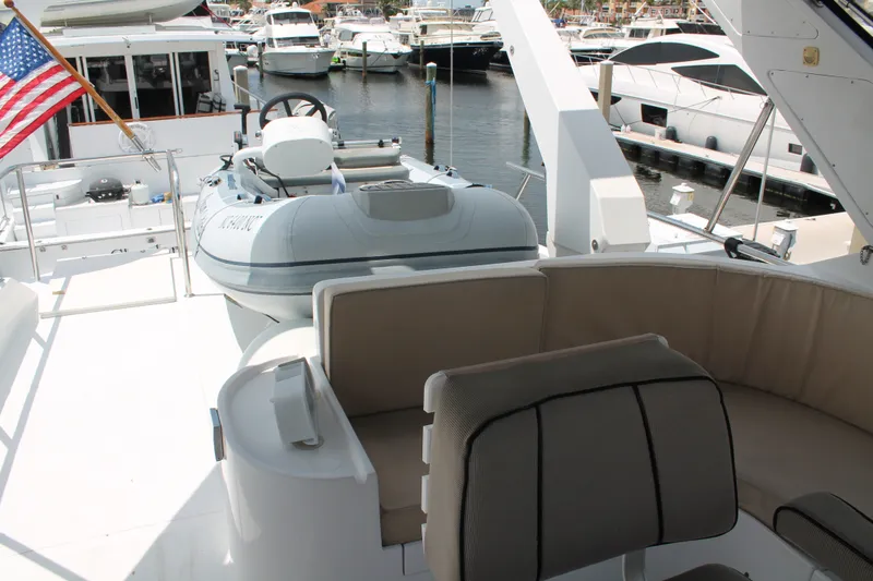Slide: The Image of 1997 McKinna 48 Pilothouse yacht deck with seating and dinghy, docked at marina. - 55