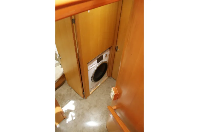 Slide: The Image of Laundry area inside 1997 McKinna 48 Pilothouse yacht with wooden cabinetry. - 26