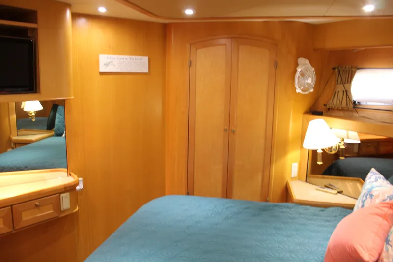 Slide: The Image of Luxurious 1997 McKinna 48 Pilothouse bedroom with wood paneling and cozy lighting. - 44