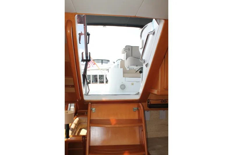 Slide: The Image of Interior view of 1997 McKinna 48 Pilothouse yacht, showcasing wooden stairs and seating area. - 47