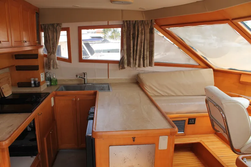 Slide: The Image of Interior of 1997 McKinna 48 Pilothouse yacht with kitchen and seating area. - 16