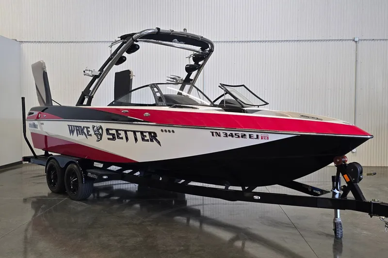 The Image of 2011 Malibu Wakesetter 247 LSV boat on trailer, red and black design. - 0