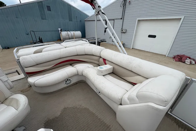 Slide: The Image of 2008 Crest 20 II pontoon boat with white and red seating, docked near a garage. - 19