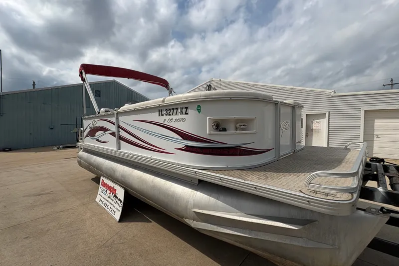 Slide: The Image of 2008 Crest 20 II pontoon boat with red accents, parked outdoors under cloudy skies. - 9