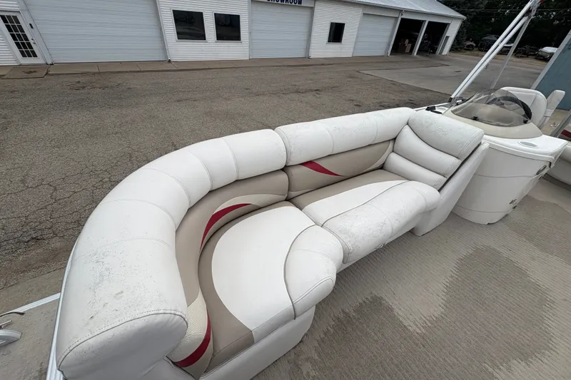Slide: The Image of 2008 Crest 20 II boat with white and beige seating, parked near a showroom. - 11