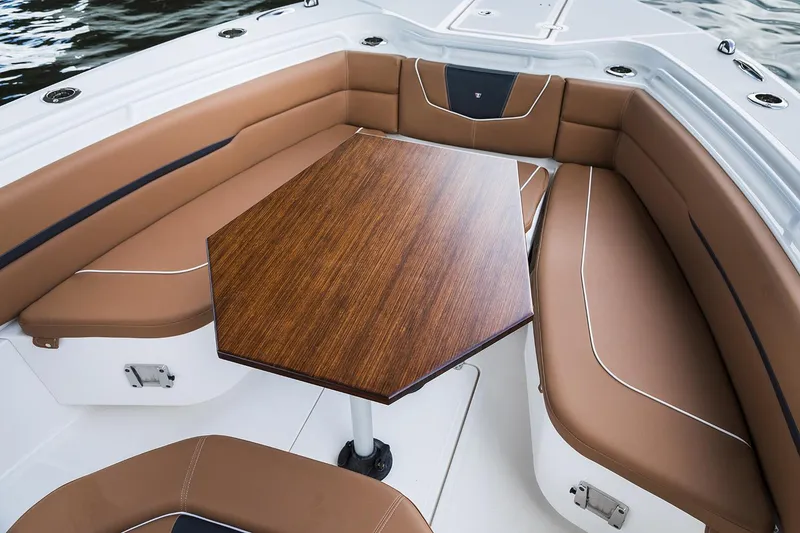 Slide: The Image of Manufacturer Provided Image: 2026 Wellcraft 302 Fisherman boat interior with brown seating and wooden table. - 4