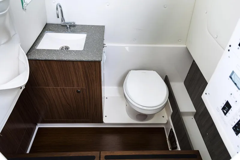 Slide: The Image of Manufacturer Provided Image: 2026 Wellcraft 302 Fisherman boat bathroom with sink, toilet, and wood accents. - 14