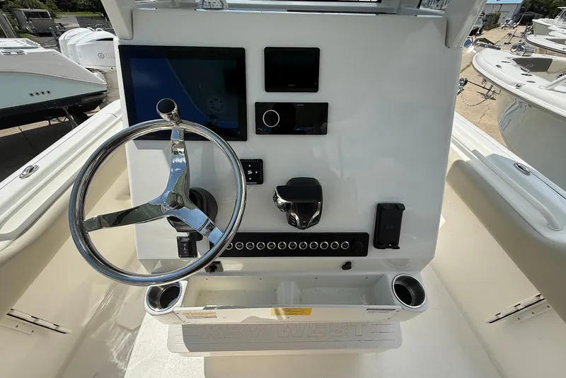 Slide: The Image of 2027 Key West 249 FS boat dashboard with steering wheel and electronic controls. - 13
