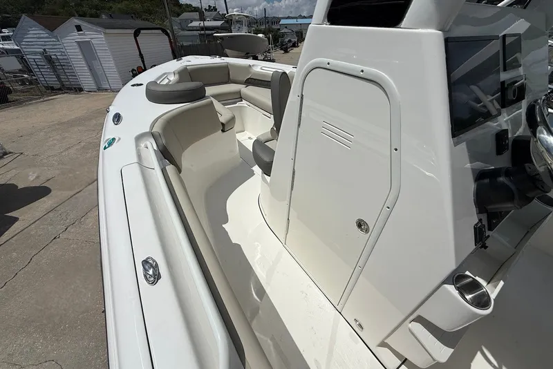 Slide: The Image of 2027 Key West 249 FS boat interior with seating and console, docked outdoors. - 16