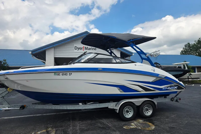 The Image of 2020 Yamaha Boats 242X on trailer at Dyer Marine, featuring sleek blue and white design. - 1