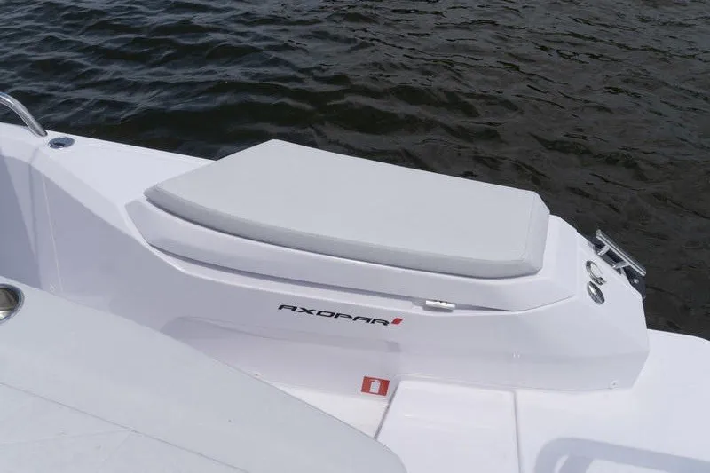 Slide: The Image of 2026 Axopar 29 XC Cross Cabin boat detail with cushioned seating by the water. - 20