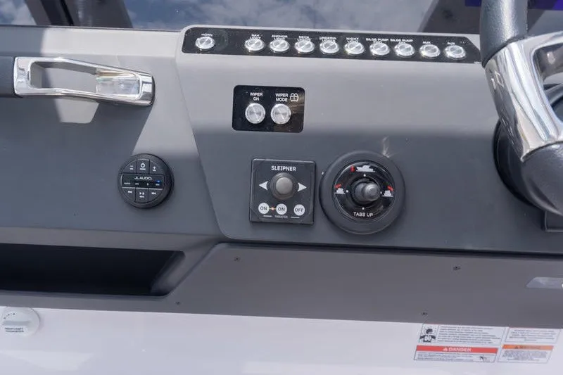 Slide: The Image of Control panel of 2026 Axopar 29 XC Cross Cabin boat, featuring steering wheel and switches. - 15