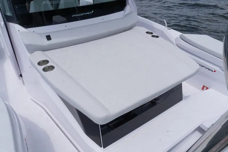 Slide: The Image of 2026 Axopar 29 XC Cross Cabin boat with cushioned seating and cup holders on deck. - 19
