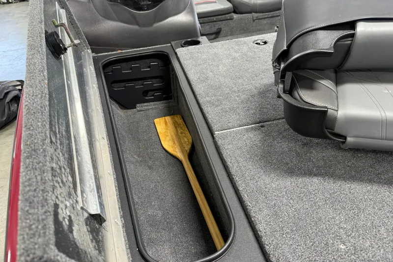 Slide: The Image of 2024 Tracker Pro Team 175 TXW Tournament Edition boat interior with storage compartment and paddle. - 15