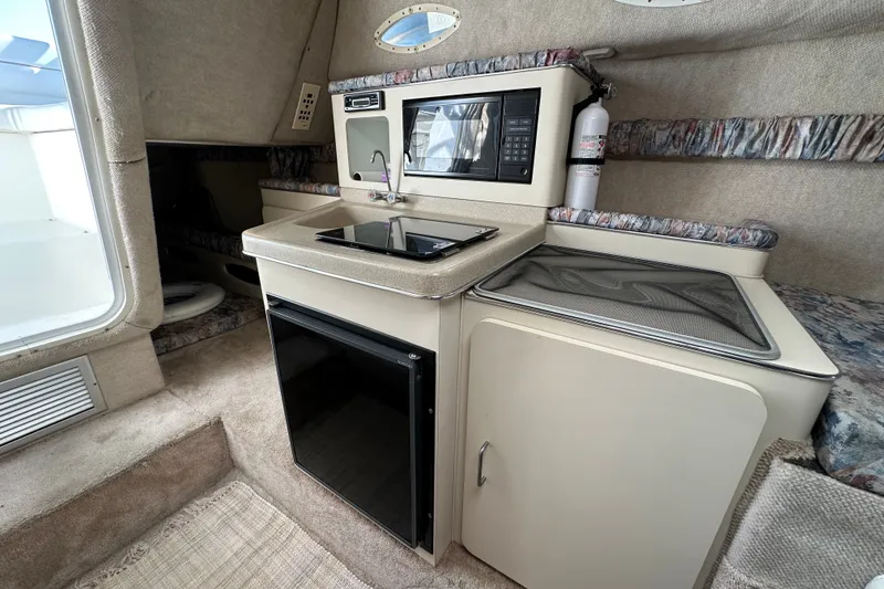 Slide: The Image of 2000 Wellcraft 2600 Martinique boat interior with kitchenette, microwave, and sink. - 14