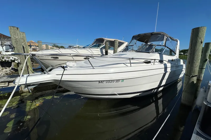 The Image of 2000 Wellcraft 2600 Martinique boat docked in a marina under clear blue skies. - 0