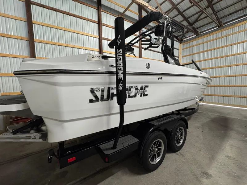 Slide: The Image of 2025 Supreme S220 boat in storage, white exterior, on a trailer. - 8