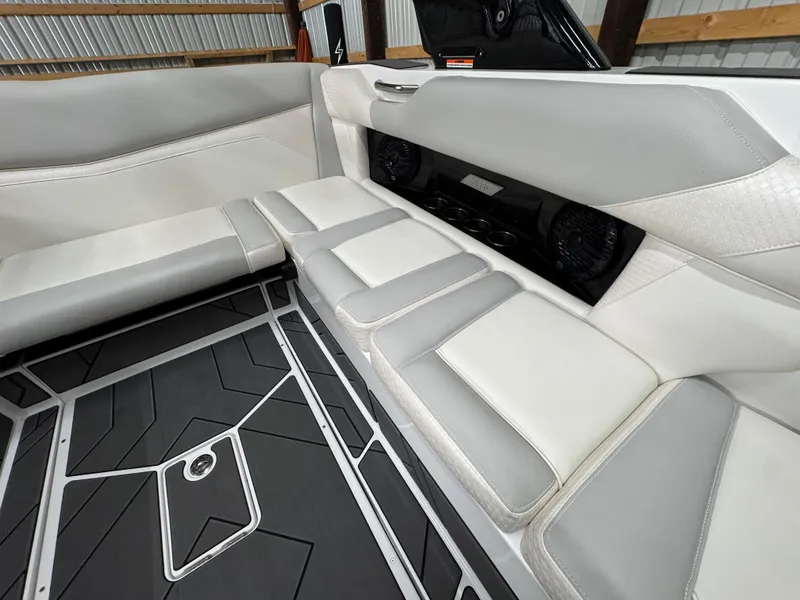 Slide: The Image of 2025 Supreme S220 boat interior with gray and white seating and modern flooring design. - 12