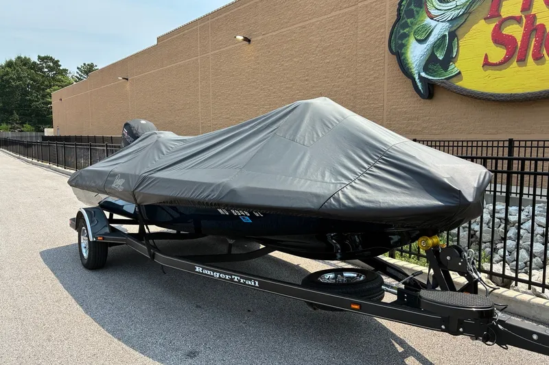 Slide: The Image of 2020 Ranger Z185 boat covered on trailer, parked outside a store. - 30