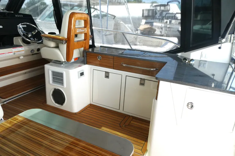 Slide: The Image of Interior of 2026 Boston Whaler 405 Conquest, featuring sleek helm and modern cabinetry. - 16