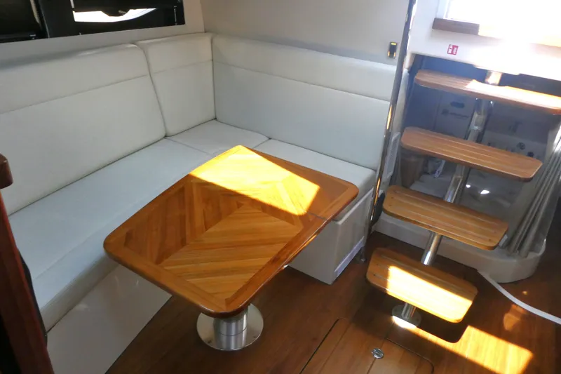 Slide: The Image of Interior of 2026 Boston Whaler 405 Conquest with white seating and wooden table. - 21