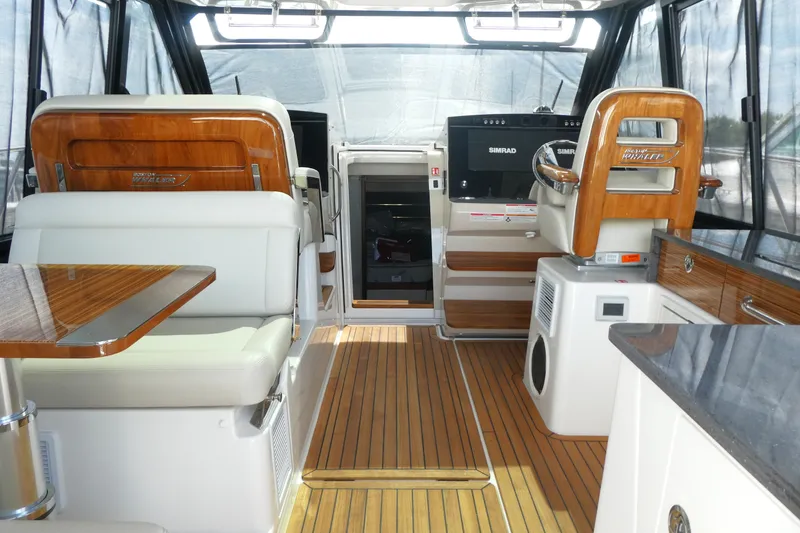Slide: The Image of Luxurious interior of 2026 Boston Whaler 405 Conquest with wood accents and modern navigation equipment. - 14