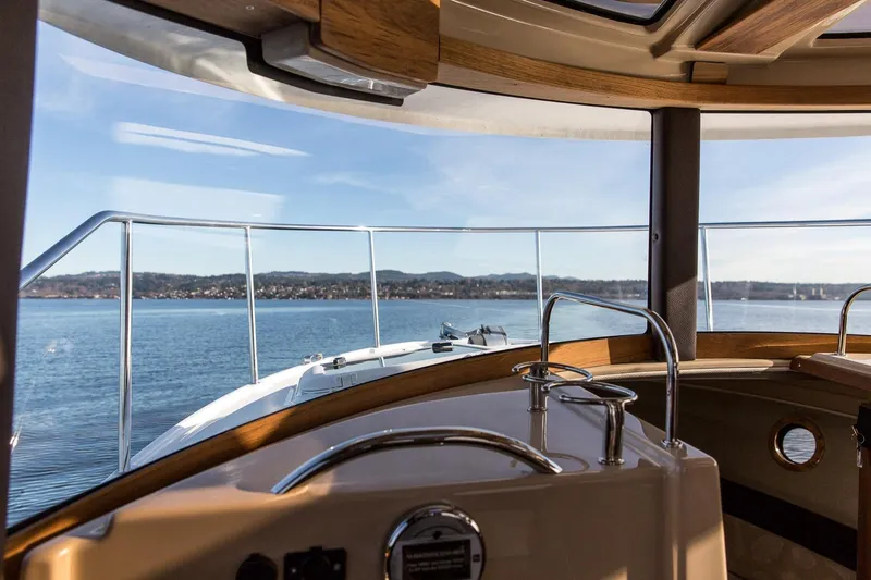 Slide: The Image of Interior view from a 2027 Ranger Tugs R-23 boat, overlooking serene waters and distant shoreline. - 18