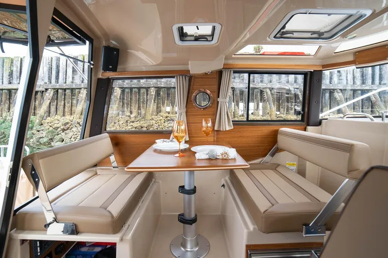 Slide: The Image of Interior of 2027 Ranger Tugs R-23 boat with dining area and windows. - 11