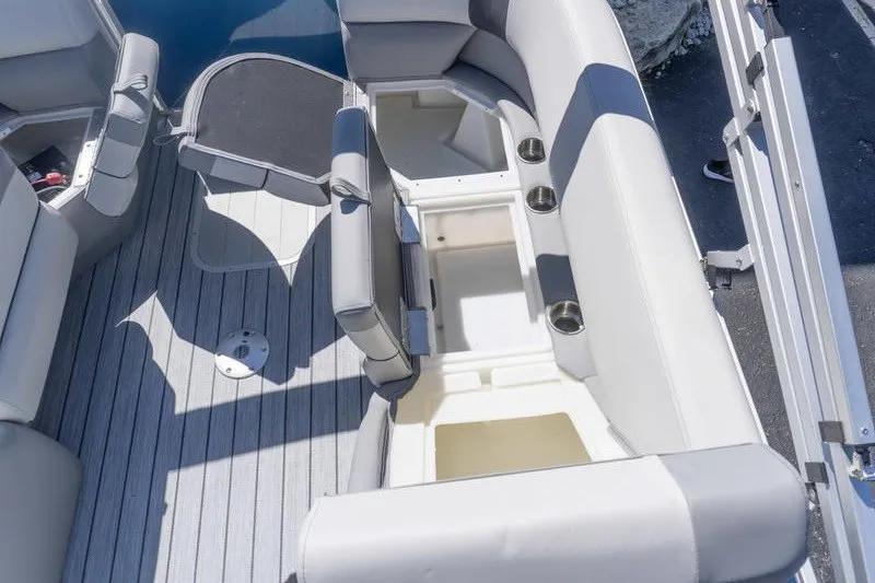 Slide: The Image of 2026 SunCatcher Select 322RC boat interior with open storage compartments and cup holders. - 24