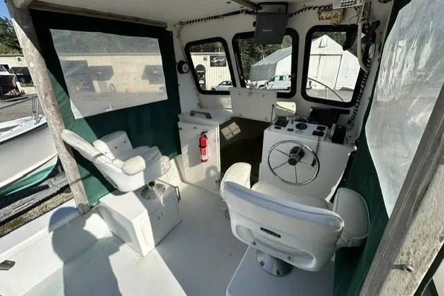 Slide: The Image of 2002 Eastern 22 Lobster Fisherman boat interior with steering wheel and seating. - 9