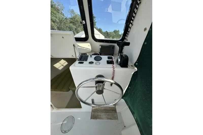 Slide: The Image of Interior view of a 2002 Eastern 22 Lobster Fisherman boat cockpit with steering wheel and controls. - 7