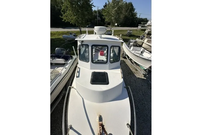 Slide: The Image of 2002 Eastern 22 Lobster Fisherman boat, docked outdoors, surrounded by greenery and other boats. - 15