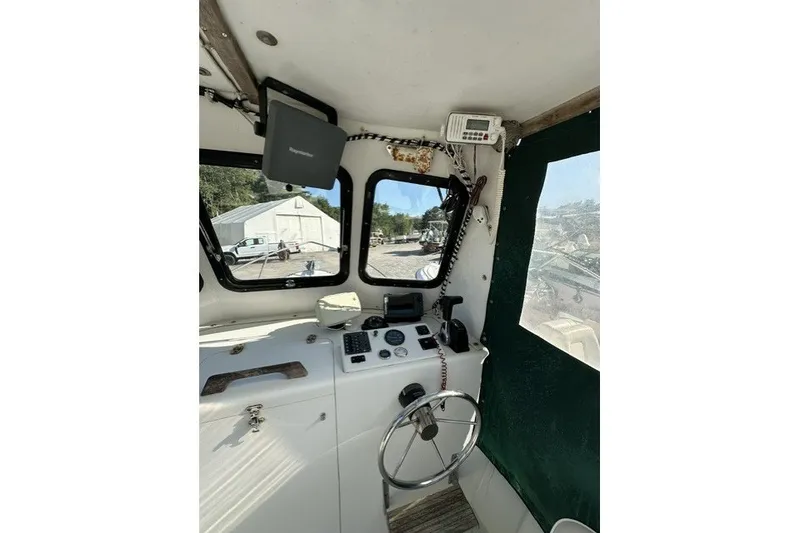 Slide: The Image of Interior of a 2002 Eastern 22 Lobster Fisherman boat, featuring steering wheel and controls. - 12