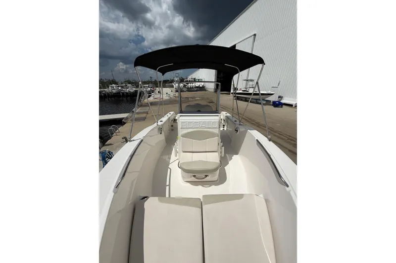 Slide: The Image of 2017 Robalo R180 Center Console boat docked, featuring spacious seating and canopy. - 13