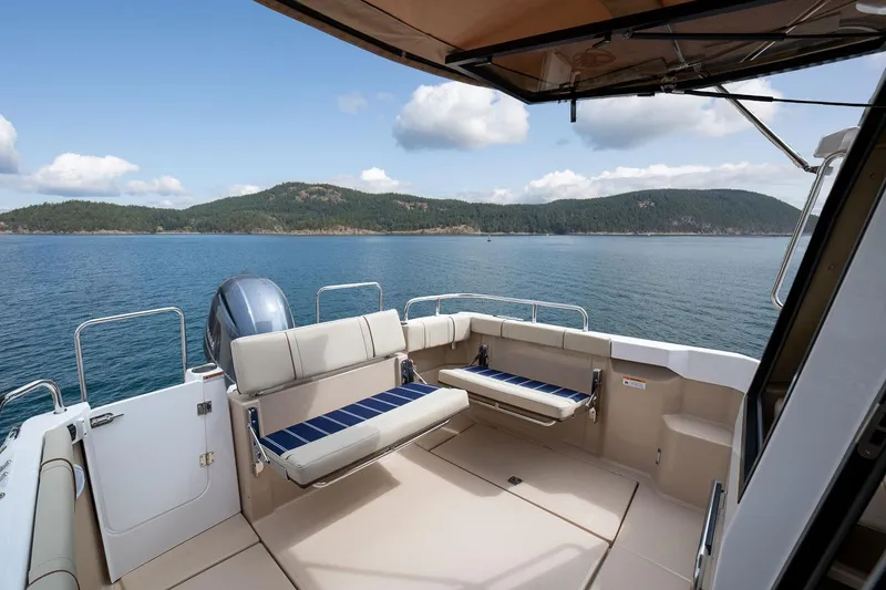 Slide: The Image of 2027 Ranger Tugs R-23 boat interior with scenic ocean view and comfortable seating. - 19