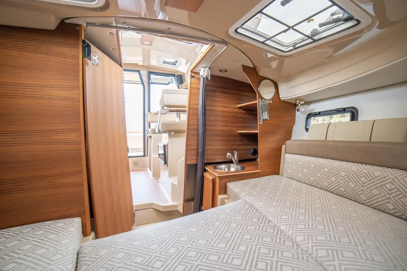 Slide: The Image of Interior of 2027 Ranger Tugs R-23 boat with wood finish and cozy seating area. - 13