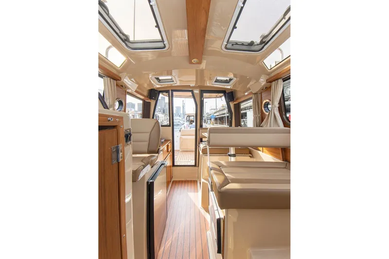 Slide: The Image of Interior of 2027 Ranger Tugs R-23 boat, featuring elegant wood finishes and spacious seating. - 16
