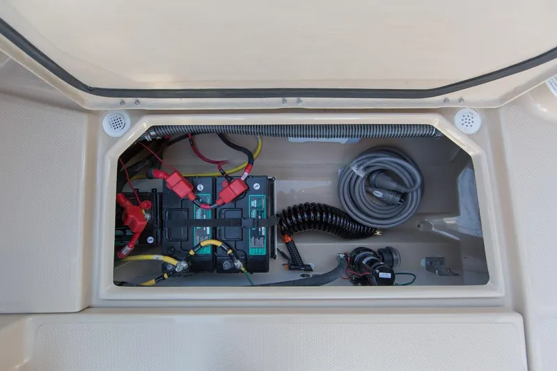 Slide: The Image of Battery compartment of 2027 Ranger Tugs R-23 boat, featuring wiring and hoses. - 23