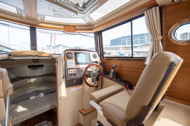 Slide: The Image of Interior of 2027 Ranger Tugs R-23 boat, featuring helm and seating area. - 15
