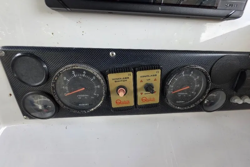 Slide: The Image of Dashboard of a 2006 Twin Vee 26 Express boat with gauges and windlass switches. - 35