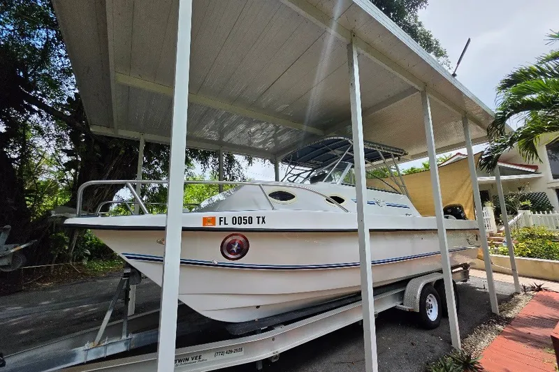 Slide: The Image of 2006 Twin Vee 26 Express boat on trailer under a canopy, side view. - 1