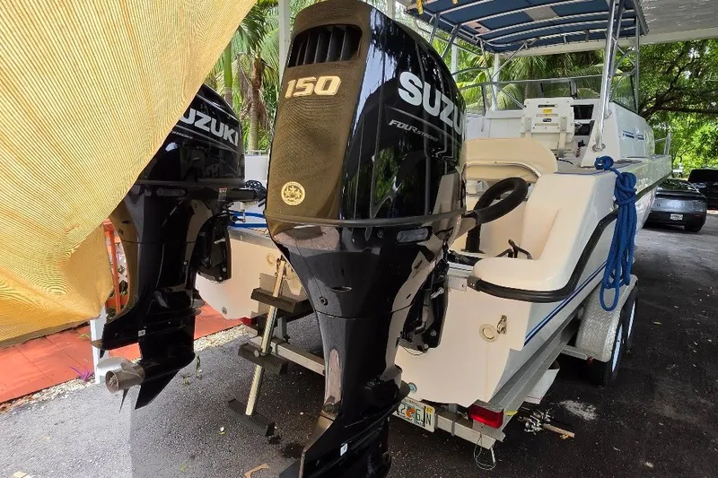 Slide: The Image of 2006 Twin Vee 26 Express boat with dual Suzuki 150 engines, parked under a canopy. - 5