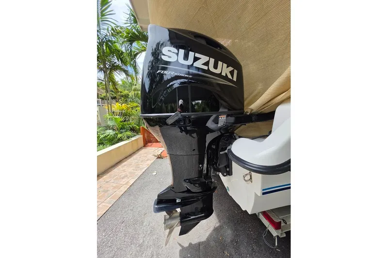 Slide: The Image of Suzuki outboard motor on 2006 Twin Vee 26 Express boat, parked outdoors. - 19