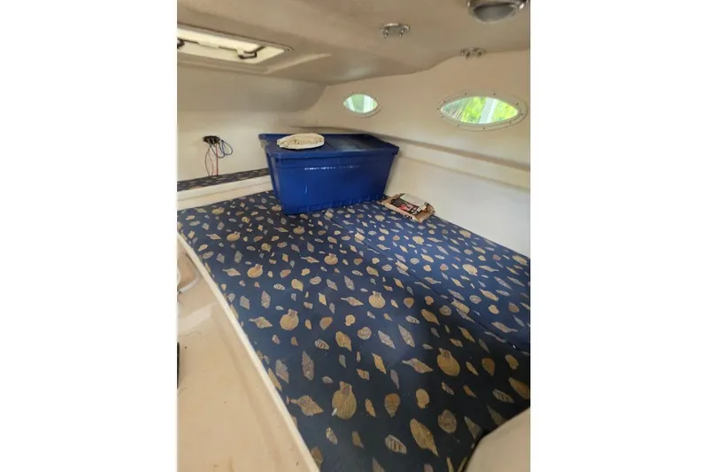Slide: The Image of Interior cabin of 2006 Twin Vee 26 Express with patterned bedding and storage. - 39