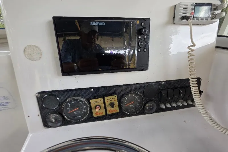 Slide: The Image of Dashboard of a 2006 Twin Vee 26 Express boat with Simrad display and gauges. - 34
