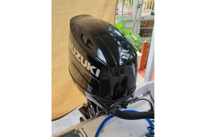 Slide: The Image of Black Suzuki outboard motor on a 2006 Twin Vee 26 Express boat. - 21