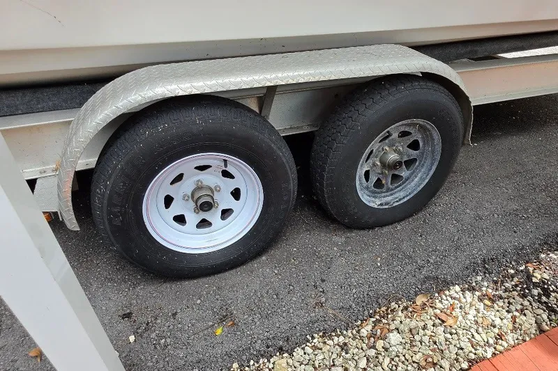 Slide: The Image of Trailer wheels of a 2006 Twin Vee 26 Express on asphalt. - 54