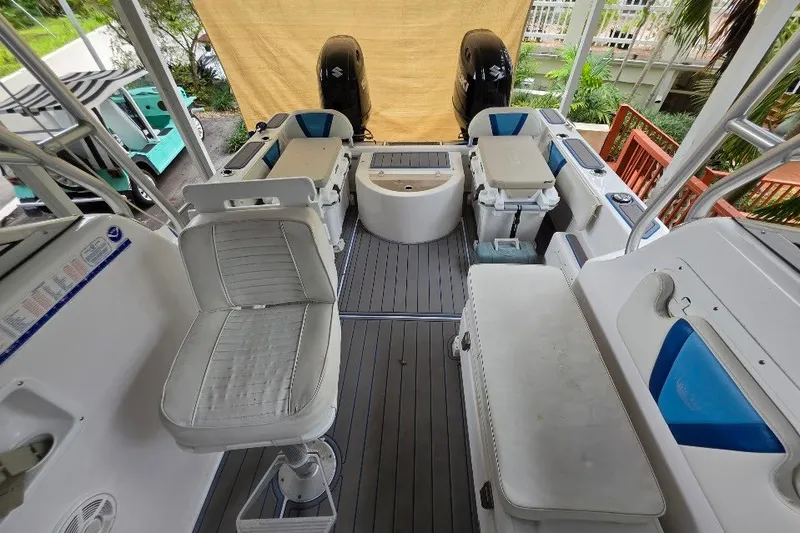 Slide: The Image of 2006 Twin Vee 26 Express boat interior with seating, coolers, and dual outboard motors. - 49