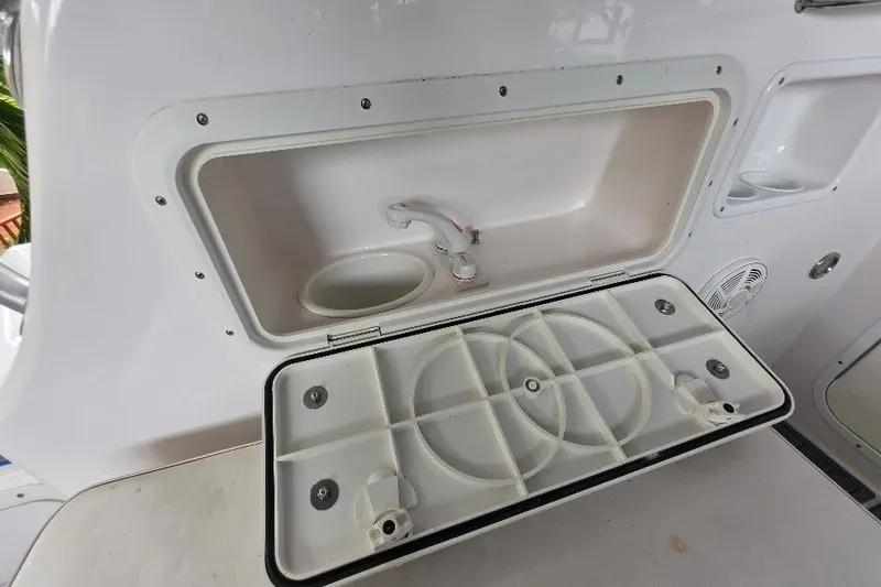 Slide: The Image of 2006 Twin Vee 26 Express boat sink and storage compartment. - 30