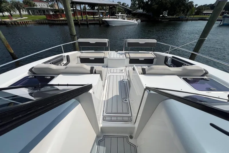 Slide: The Image of Aquila 36 Sport 2019 boat deck with seating, docked by a serene waterfront. - 16